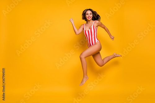 Full length body size view of her she nice attractive chic cheerful slim slender fit lady jumping running having fun enjoying weekend isolated on bright vivid shine vibrant yellow color background