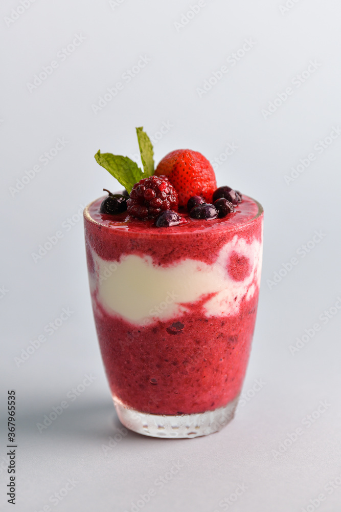 Mixed berry smoothie mixed with yogurt By blending thoroughly in clear glass With berries on top and for those who take care of their shape selective focus at fruits on top Mixed berry smoothie mixed with yogurt By blending thoroughly in clear glass With berries on top and for those who take care of their shape selective focus at fruits on top