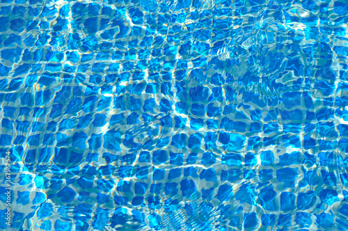 Bild auf Leinwand blue mosaic pool bottom filled with water, bright reflections and small waves on