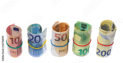 Money rolls, rolled up euro banknotes, bills of various monetary values tied up with rubber band isolated on white background
