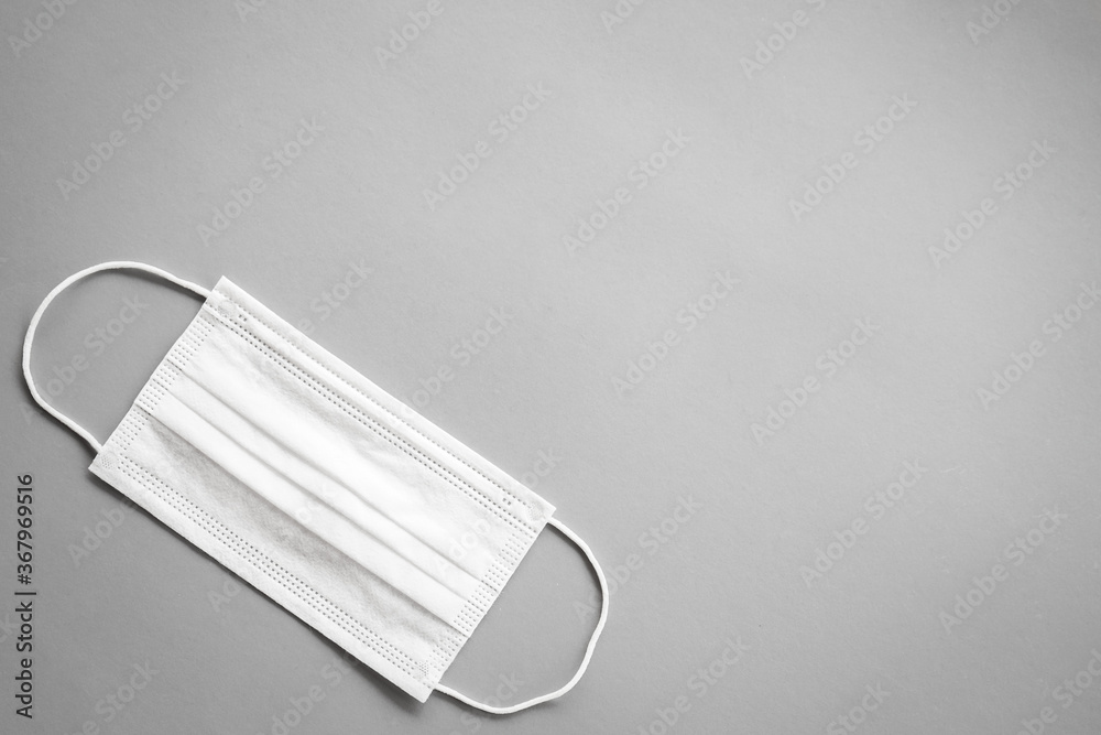 White surgical mask with rubber ear straps on grey background White surgical mask with rubber ear straps on grey background