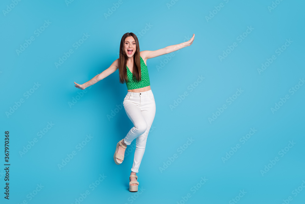Full size photo of candid crazy girl enjoy rejoice free time weekend hold hand imagine she fly plane wear singlet isolated over blue color background