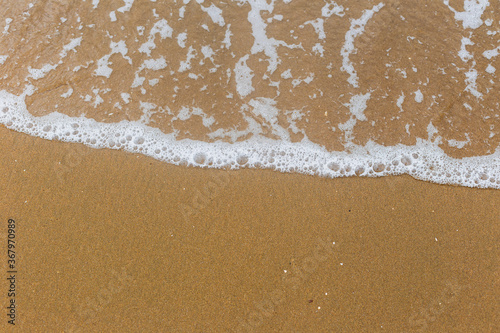 Sandy beach with waves. Empty sea and beach background with copy space