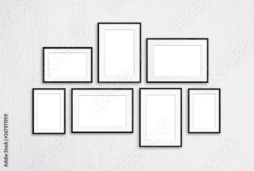 Photo frames set isolated on white textured wall, seven blank realistic frameworks, interior decor mock up