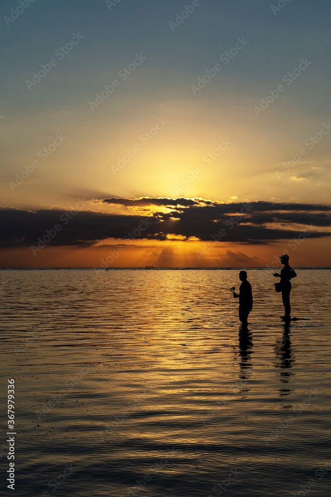 silhouette of a couple walking on the beach at sunset in Indonesia