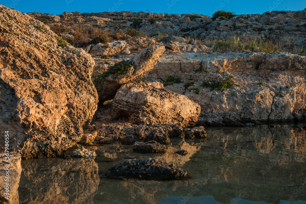 Rocks and calm water at Slug's Bay, Mellieha