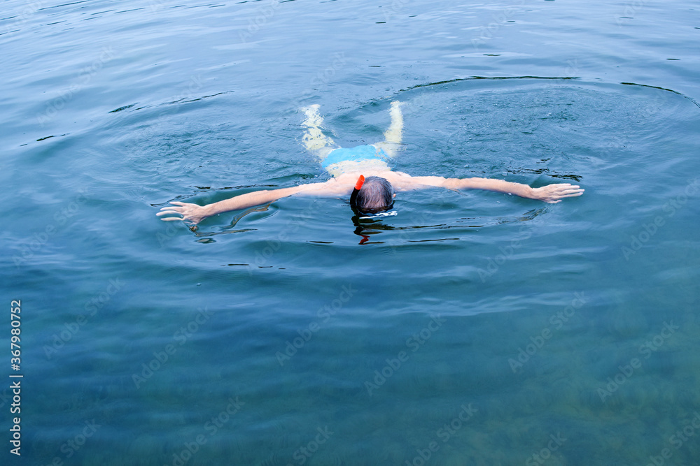 Man swims in the sea wearing a mask.
Copy space.