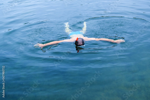 Man swims in the sea wearing a mask. Copy space.