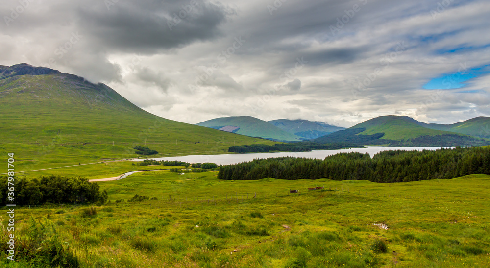 A view over Glen Tulla and with Loch Tulla in the background, surrounded by mountains and woodland