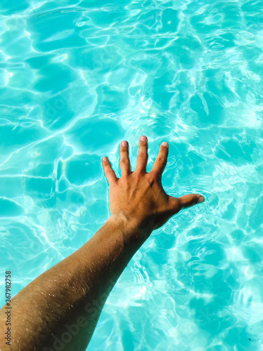 Man´s hand on turquoise water