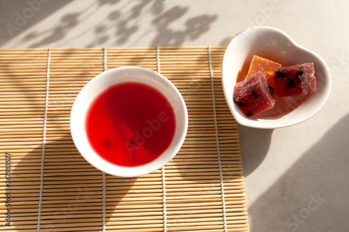 Schizandra tea is a traditional Korean drink. It is brewed from Chinese schisandra berries used in herbal medicine. Nearby are oriental sweets in a heart-shaped bowl photo