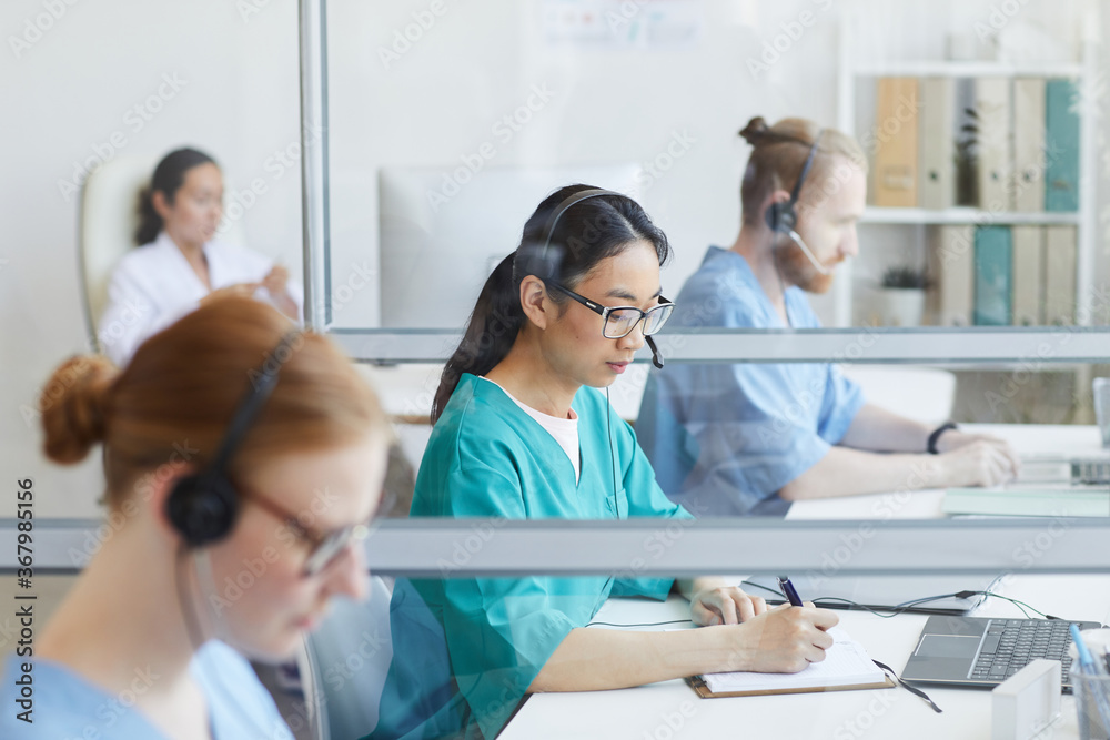 Fototapeta premium Medical team using headsets while working at their workplace in medical call center
