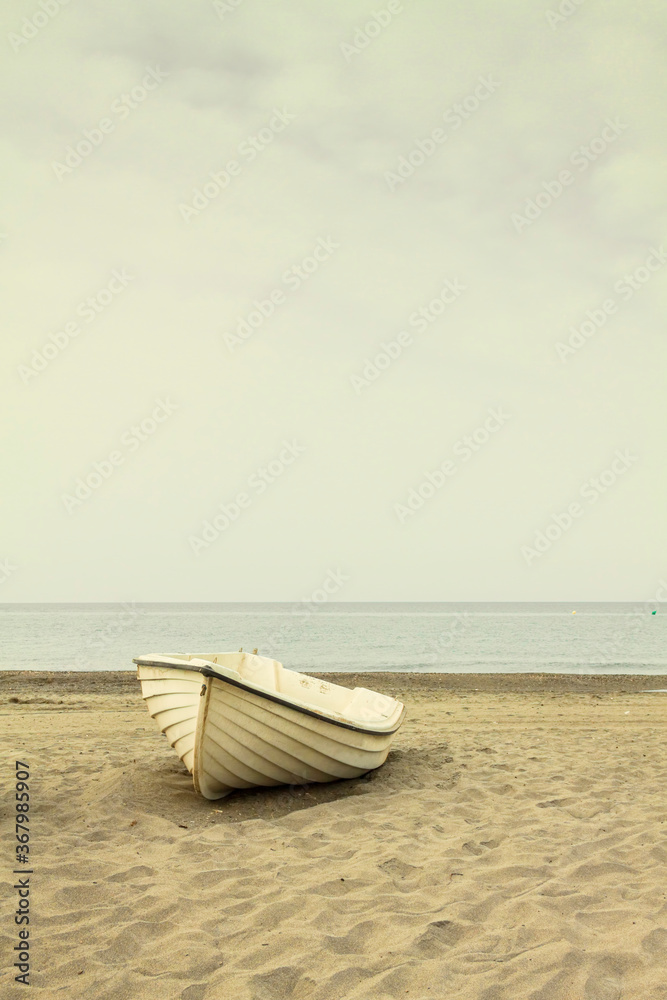 a boat in the sand on the beach of the mediterranean sea. a boat in the sand on the beach of the mediterranean sea.