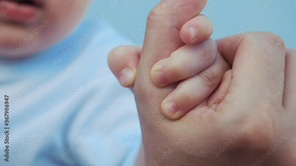 baby newborn holding a mom hand. kid dream concept. closeup baby hand