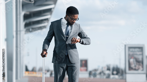 Foto Man With Travel Suitcase Checking Time Standing At Airport, Panorama