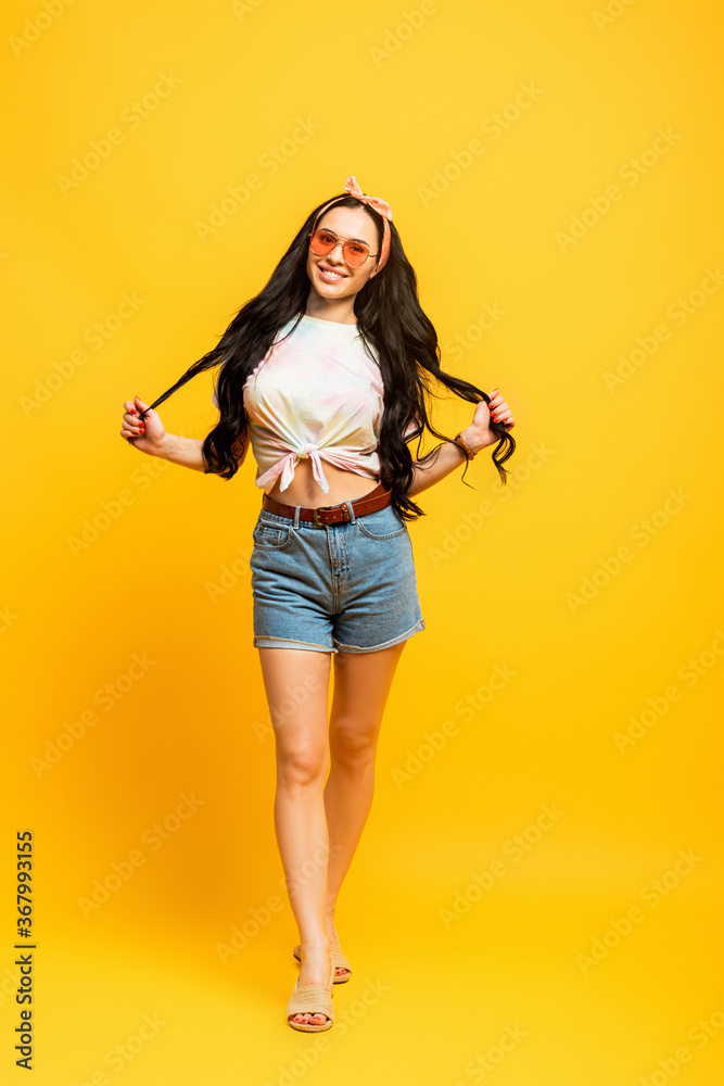 smiling stylish summer brunette girl on yellow background smiling stylish summer brunette girl on yellow background