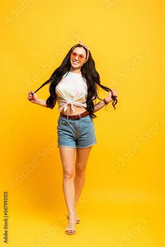 smiling stylish summer brunette girl on yellow background