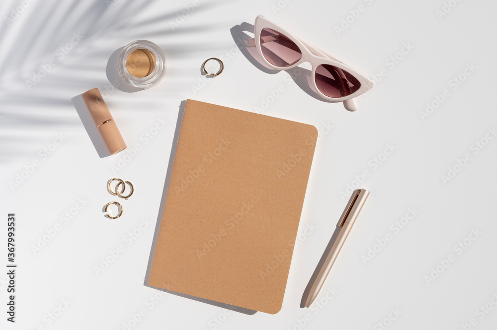 Kraft Paper cover notebook mockup. Woman's trendy desk. Beauty accessories, jewelry and palm leaf shadow. Flat lay with copy space Kraft Paper cover notebook mockup. Woman's trendy desk. Beauty accessories, jewelry and palm leaf shadow. Flat lay with copy space