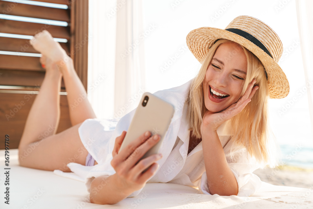 Image of laughing woman waving hand and taking selfie on cellphone Image of laughing woman waving hand and taking selfie on cellphone