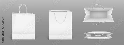 White paper shopping bags front and top view. Vector realistic mockup of blank packet with handles isolated on gray background. Template for corporate design on cardboard bag for store or market photo