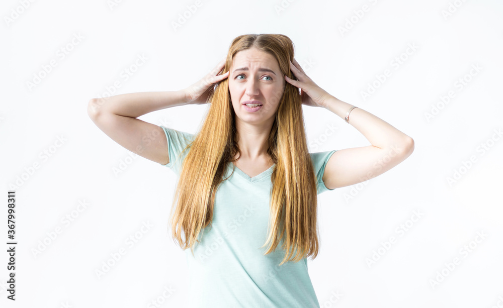 Girl looks surprised to the side, hands holding her head on a white background