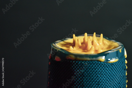 Yellow liquid splash on a waterproof speaker