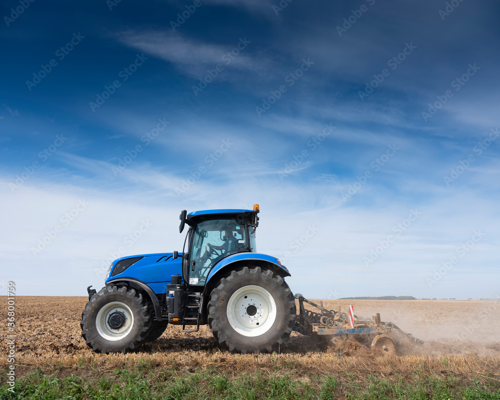 farmer in tractor with harrow on field in the north of france farmer in tractor with harrow on field in the north of france