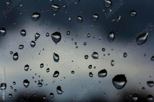 A small raindrop rests on the glass after rain.