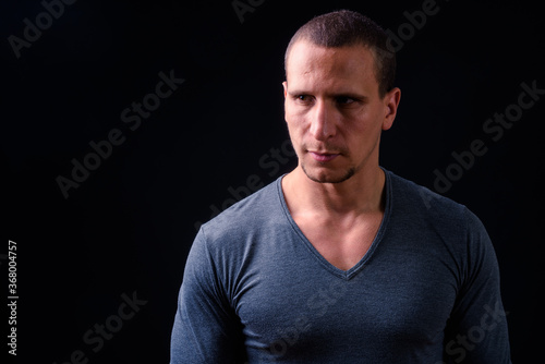 Face of man with short hair against black background © Ranta Images