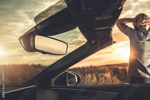 Relaxed Man Enjoying Summer Sunset While on Road Trip in Convertible Car