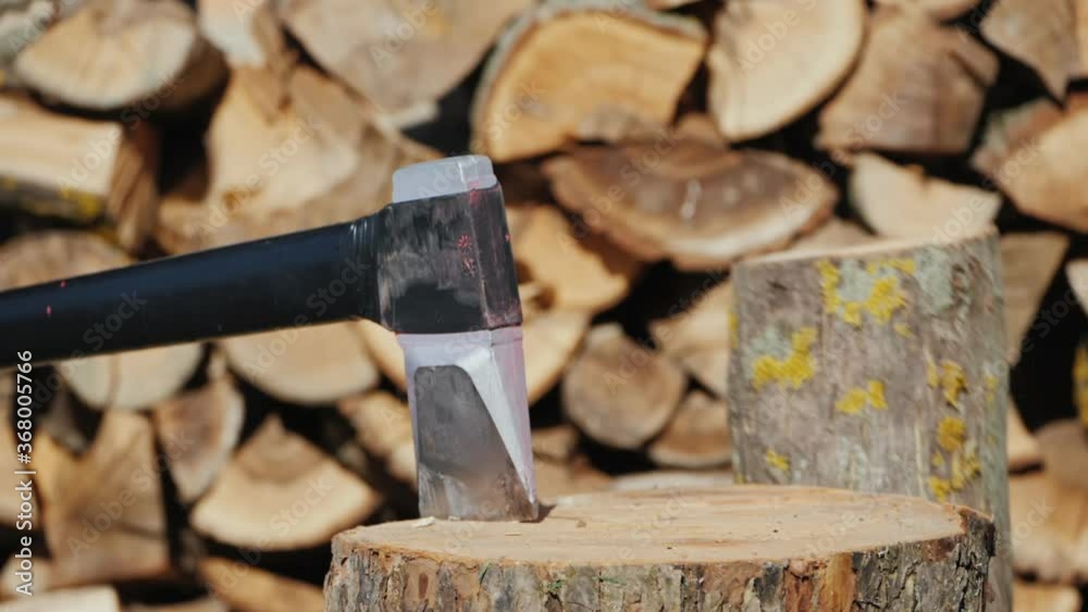Ax splits a log, harvesting firewood Ax splits a log, harvesting firewood