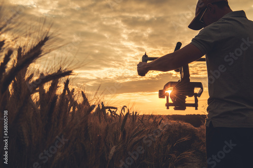 Video Camera Operator with Gimbal Stabilization Taking Scenic Sunset Shot photo