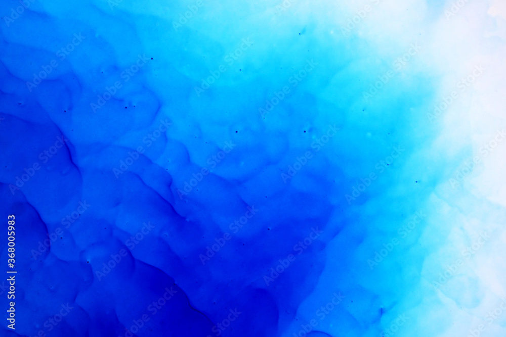 Fototapeta premium Blue Background. Blue ink texture with abstract washes and paint stains on the white paper background. Hand painted background. Blue ink background for design