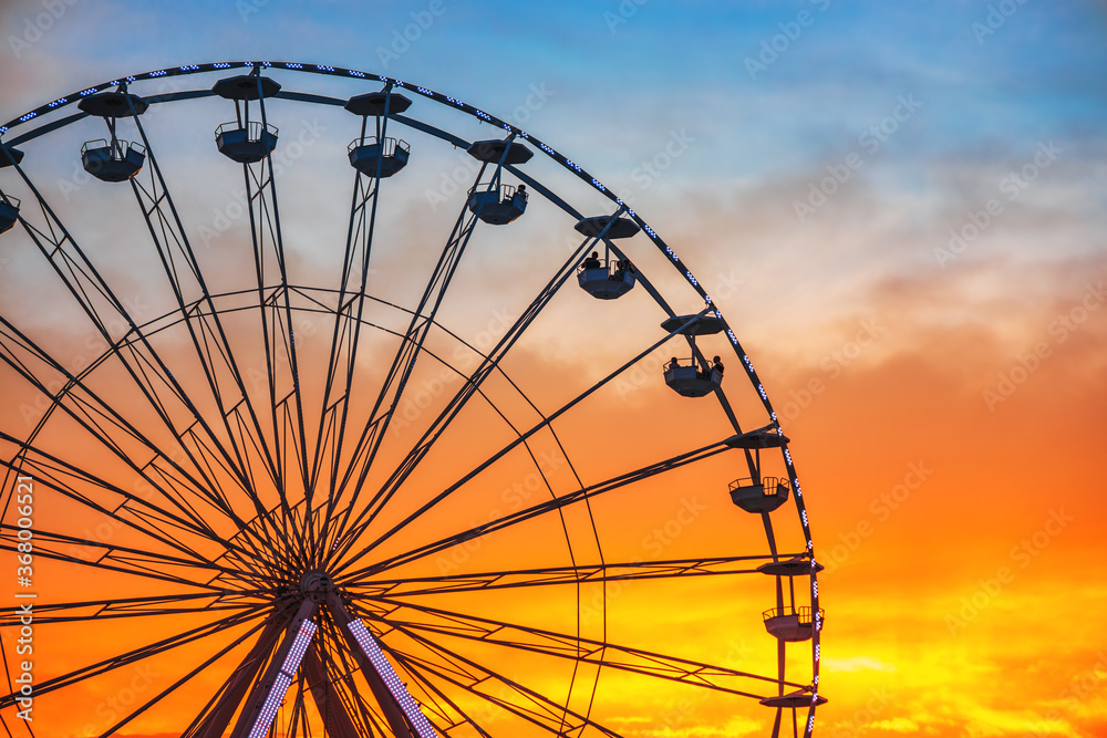 Ferris Wheel with sunset sky and clouds Ferris Wheel with sunset sky and clouds