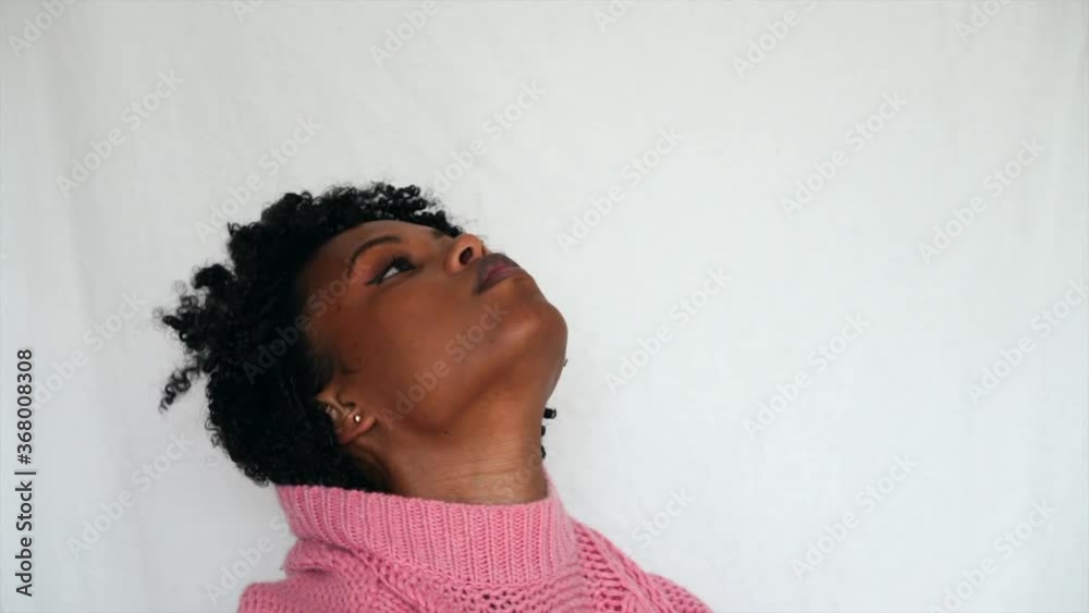 Black woman with afro hair putting on jumper Black woman with afro hair putting on jumper