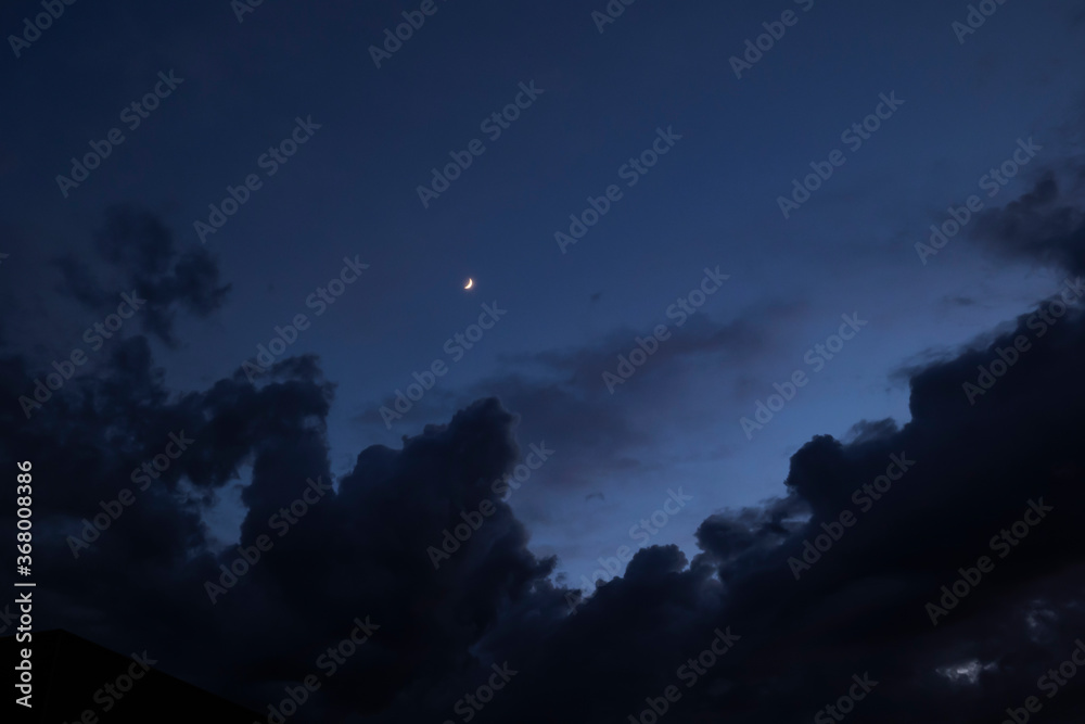 A scenic shot of the crescent moon shining in the cloudy night sky A scenic shot of the crescent moon shining in the cloudy night sky