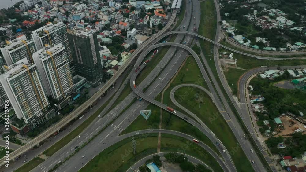 Top down aerial view of freeway interchange with interesting looped roads and traffic. Camera pans from right to left revealing the built up landscape Top down aerial view of freeway interchange with interesting looped roads and traffic. Camera pans from right to left revealing the built up landscape