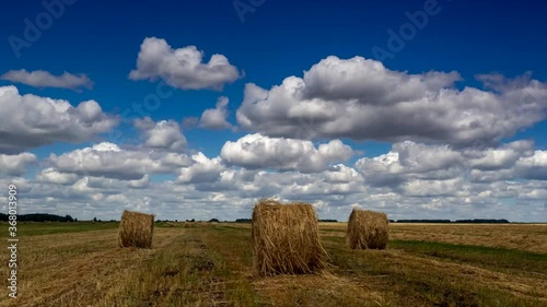 timelapse with clouds and round haystacks on a windy day