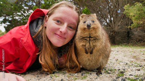 Picture of a tourist woman / girl posing with a cute quokka on Rottnest Island near Perth in Western Australia photo