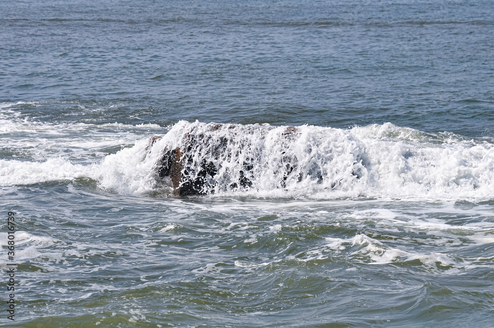 Obraz premium Sea breeze breaking on the rocks