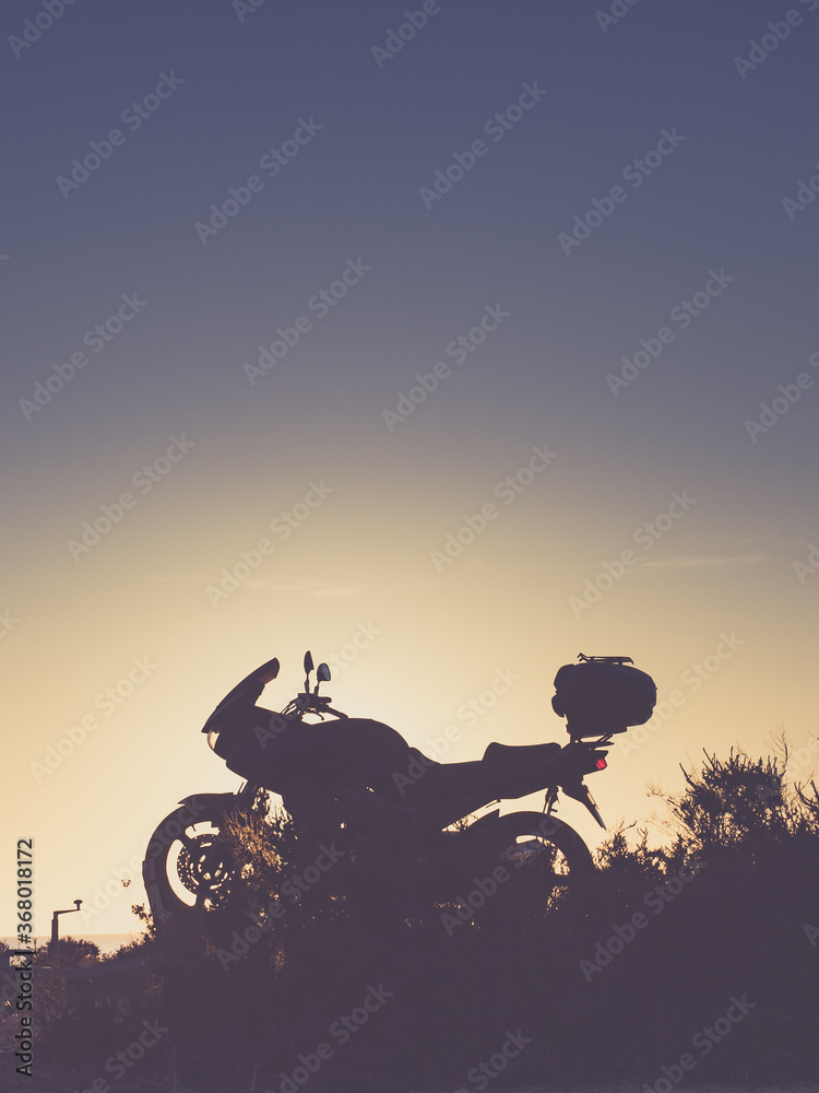 Motorcycle on beach at sunset