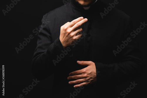 cropped view of priest gesturing while praying isolated on black © LIGHTFIELD STUDIOS