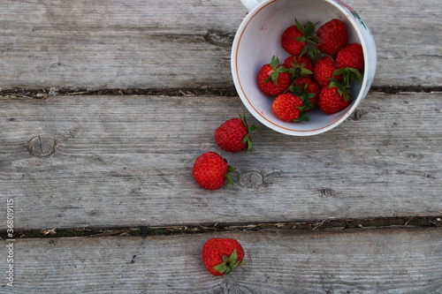 strawberries in a cup on a wooden old background