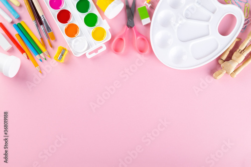 Various school office and painting supplies on pink background. Back to school concept. Top view. Copy space