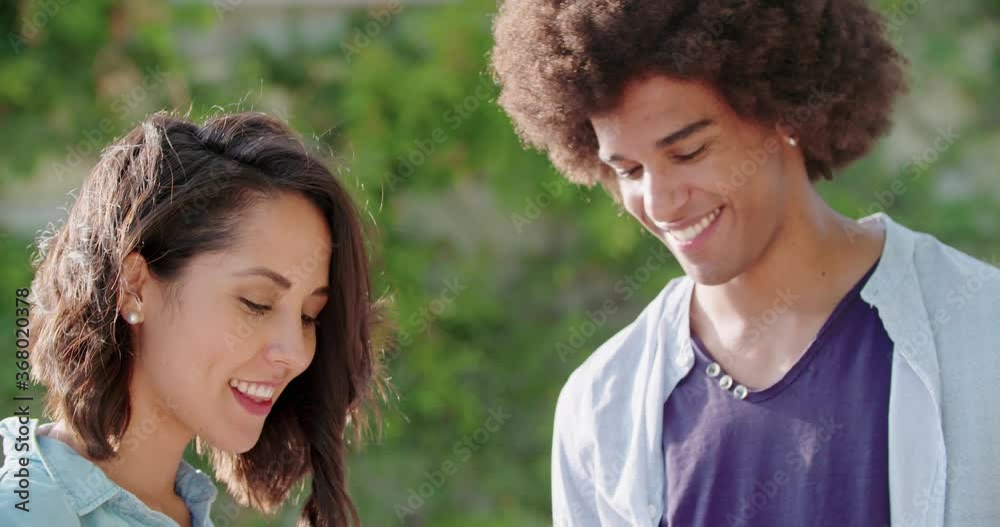 Romantic young woman and man smiling portrait.Slow motion. Casual dressed smiling multi ethnic man and woman outdoor portrait at sunset Romantic young woman and man smiling portrait.Slow motion. Casual dressed smiling multi ethnic man and woman outdoor portrait at sunset