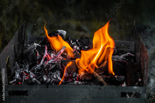 Burning coals in the grill, flame and smoke.