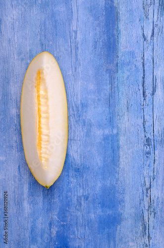 Slices of raw melon on an old blue wooden background.