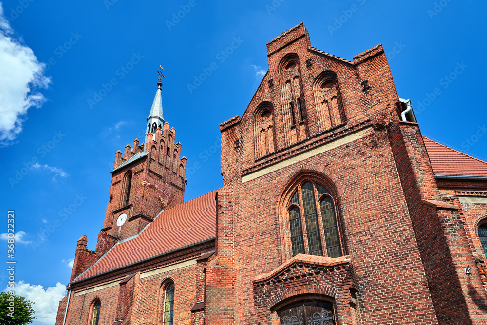 historic, gothic red brick church with a belfry in the village of Bledzew