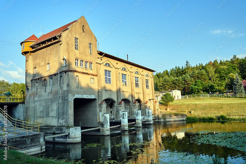 the river and the building of a historic hydroelectric power plant in Bledzew in Poland - obrazy, fototapety, plakaty 