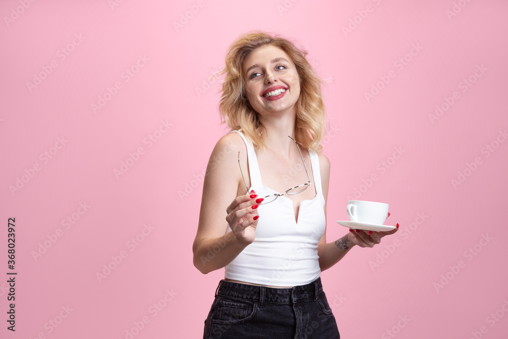 Happy coffee time. Caucasian young woman's portrait isolated on pink studio background. Beautiful blonde model. Concept of human emotions, facial expression, sales, ad, youth. Copyspace. Happy coffee time. Caucasian young woman's portrait isolated on pink studio background. Beautiful blonde model. Concept of human emotions, facial expression, sales, ad, youth. Copyspace.